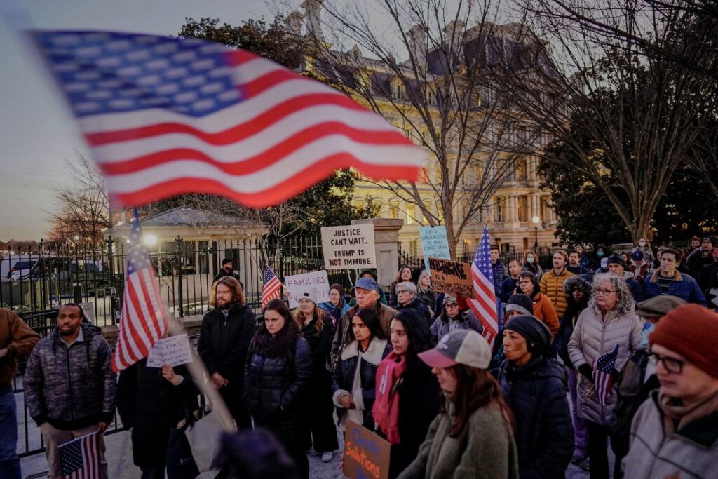 People rally in support of federal funding and in opposition to Trump's order to pause all federal grants and loans near the White House on Tuesday.