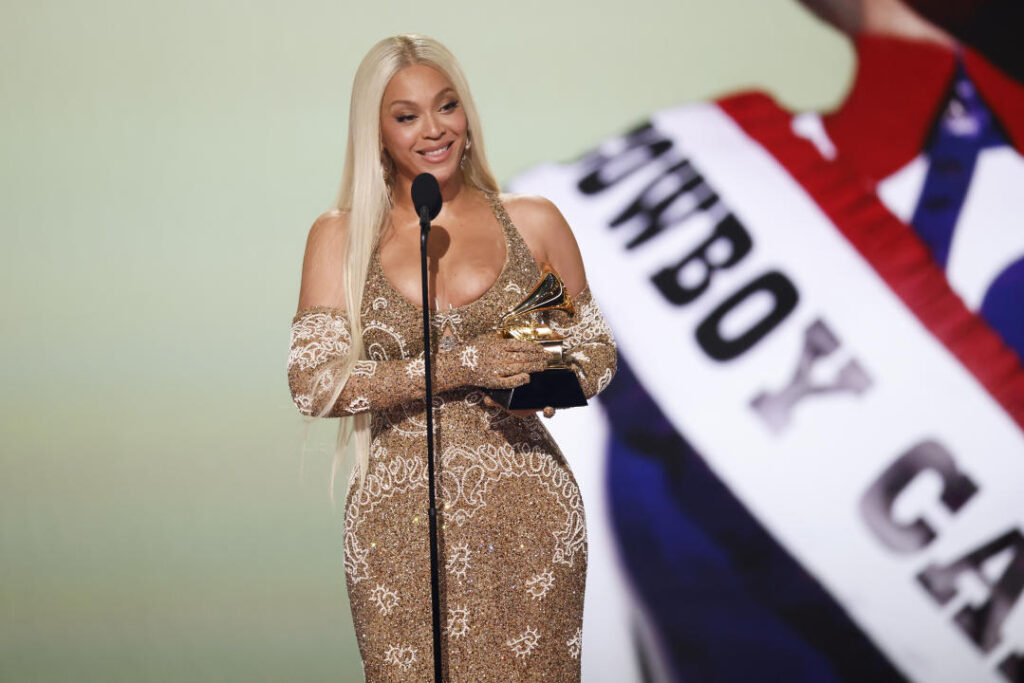 Beyoncé, in long blond hair and form-fitting, beaded gown.