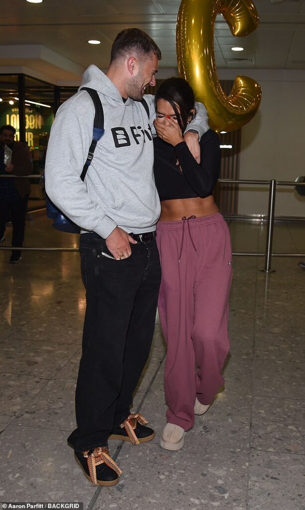 Actress Ekin looked overwhelmed with the attention as she posed in an ab-flashing black crop top and dark mauve joggers