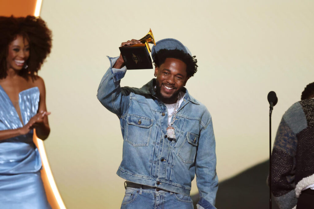 Kendrick Lamar holds up his Grammy for Record of the Year.