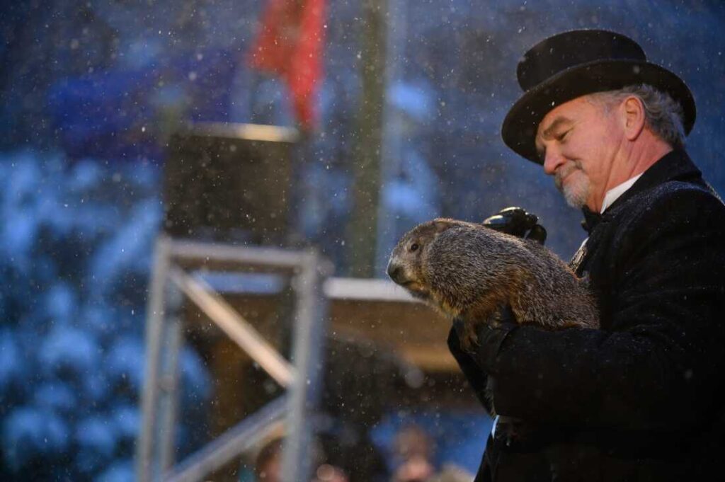 Groundhog handler John Griffiths holds Punxsutawney Phil, who did not see his shadow, in 2020.