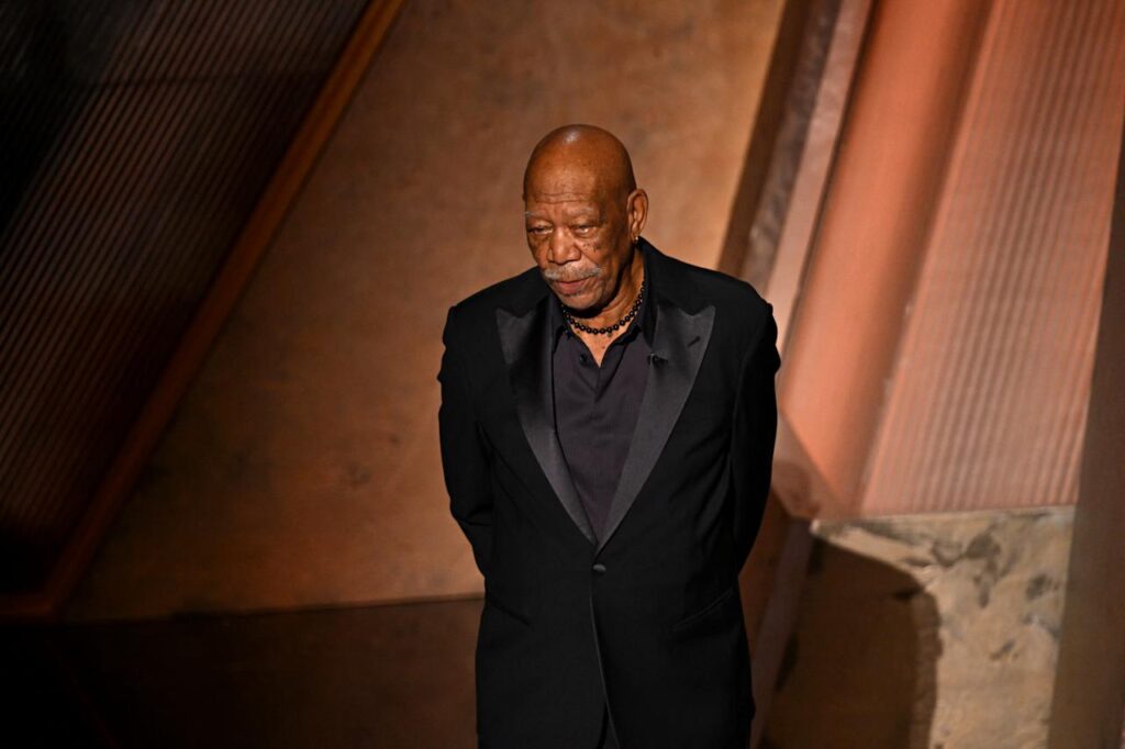 A somber Morgan Freeman in a black jacket with silk lapels.