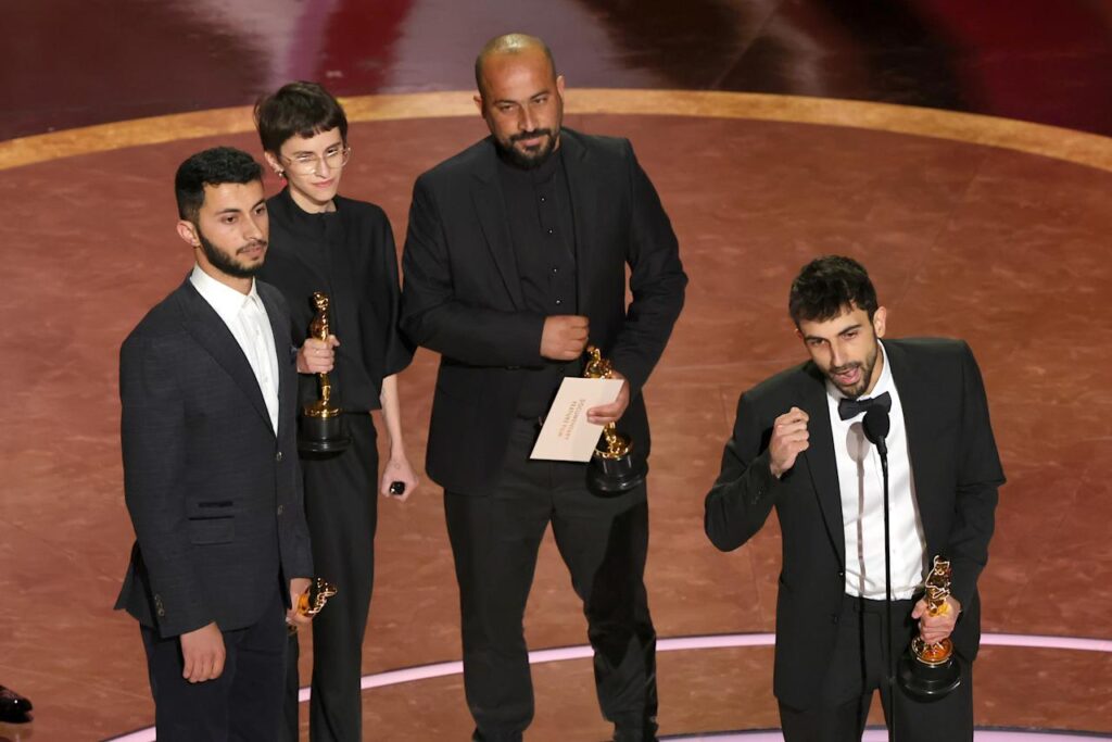 Looking grim, the group of four wait onstage while Yuval Abraham takes the microphone.