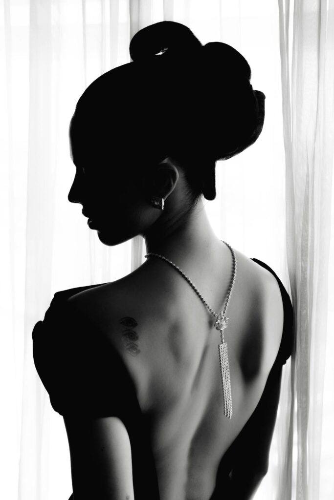 silhouette of a person with a decorative necklace and tattoo