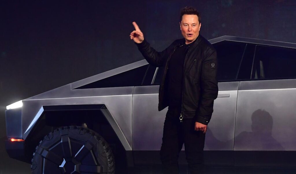 Elon Musk standing by a Cybertruck.